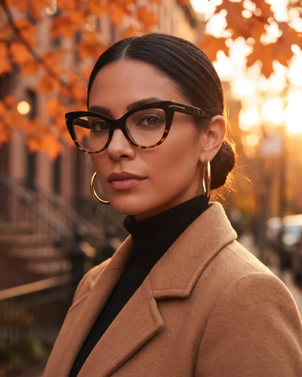 Woman in a camel coat on a New York street in autumn wearing black and tortoise cat-eye glasses