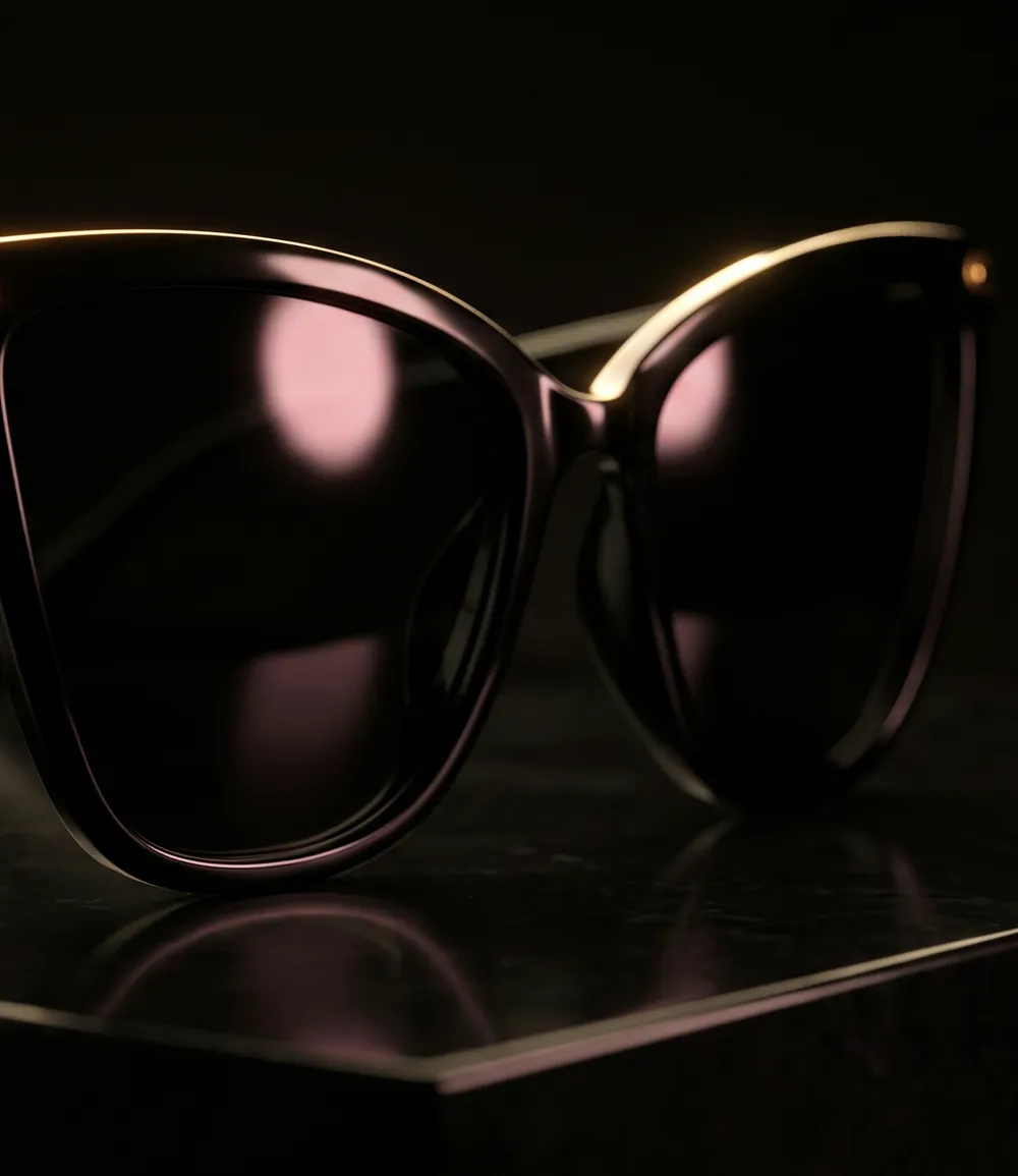 Black cat-eye sunglasses with a pink highlight on black marble