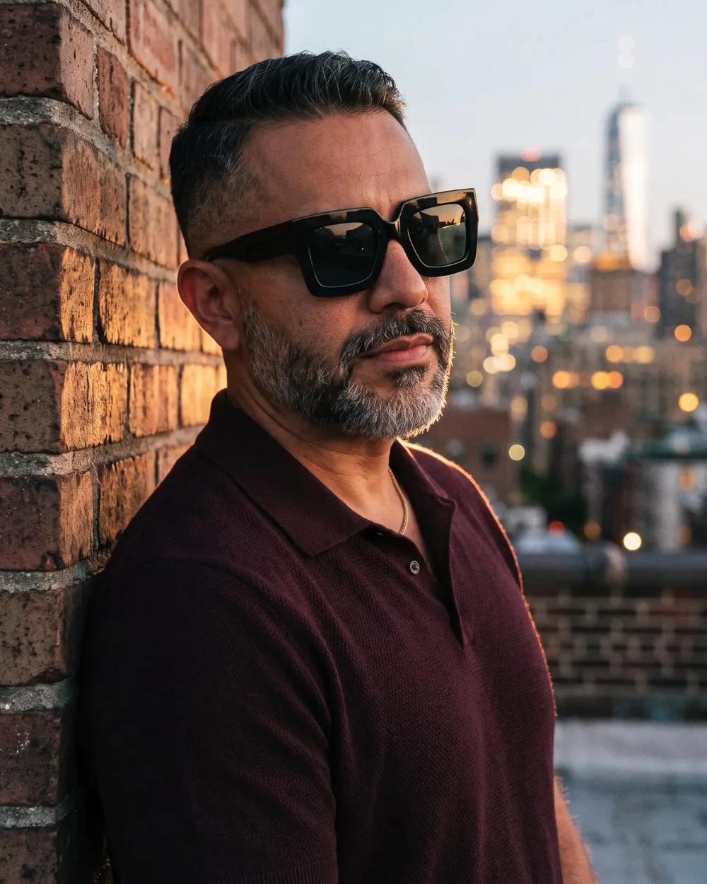 Man on a Manhattan rooftop at dusk wearing the Bold Square sunglasses